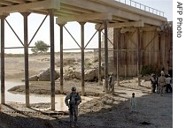 A soldier from the International Security Assistance Force (ISAF) stands guard as construction takes place at a bridge in Farah, Afghanistan (2006 file photo)