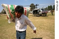 A man unloads a bag of rice from helicopter delivering relief aid in village of Palto, Peru, 20 Aug 2007