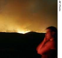A man looks at blazes burning a mountain next to the village of Theologos in Evia island, 27 Aug 2007