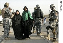 Female pilgrims walk past Iraqi security forces, 27 Aug 2007