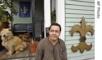 Javier Tobar poses in front of his home where he covered the mark left by post-Katrina body searchers with a fleur-de-lis, in New Orleans, 23 Aug. 2007