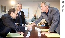 President Bush (right) shakes hands with Iraqi Prime Minister Nouri al-Maliki while President Jalal Talibani looks on