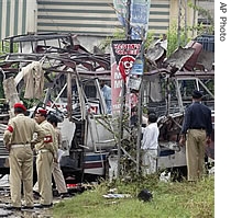 Pakistani security officials examine a damaged bus at the site of bomb blast in Rawalpindi, Pakistan, 04 Sept 2007