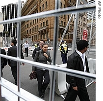 Pedestrians walk through fences that cordon off streets around the Sydney Convention 