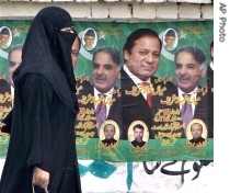 A woman walks past posters of Nawaz Sharif and his brother Shahbaz Sharif displayed by their supporters in Lahore, 03 Sep 2007
