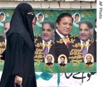 A woman walks past posters of  Nawaz Sharif and his brother Shahbaz Sharif displayed by their supporters in Lahore, 03 Sep 2007