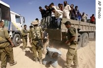 Israeli soldiers unload a large group of detained Palestinians from a truck following an army operation in the Gaza Strip, 06 Sep 2007