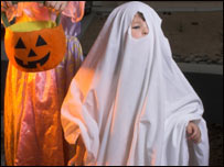 A child dressed up as a ghost on Halloween