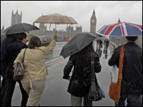 People walking in London with umbrellas
