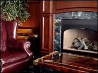 An armchair next to a fireplace
