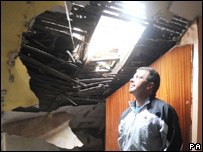 A man assessing the damage to his roof in the earthquake