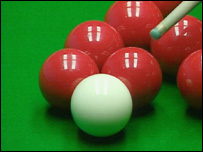 A snooker cue about to hit a ball