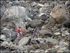 Villagers walk among rocks from landslide triggered by earthquake in West Java, Indonesia, 3 September 2009