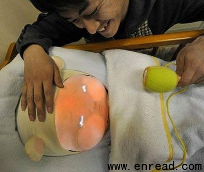 An engineering student soothes Yotaro, a robot which emulates a real baby at Tsukuba University in Japan. Yotaro