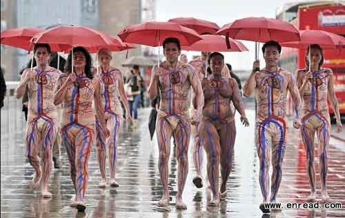 The group walk through central London wearing only skin-coloured underwear and sandals as an inch and a half of rain fell