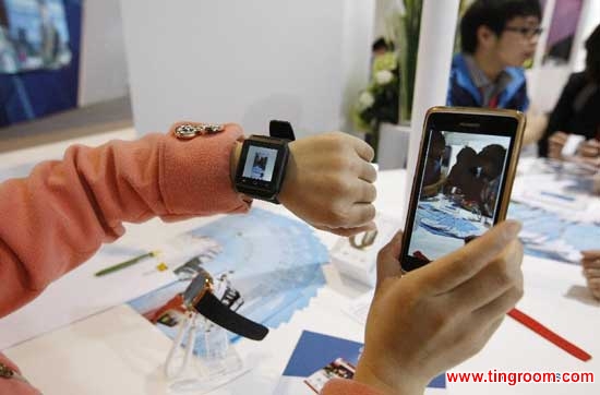 A staff member shows an electronic product, which can be connected with mobile phones with bluetooth technology, during the 2nd China (Shanghai) International Technology Fair in Shanghai, east China, April 24, 2014. The fair kicked off here Thursday. (Xinhua/Fang Zhe)