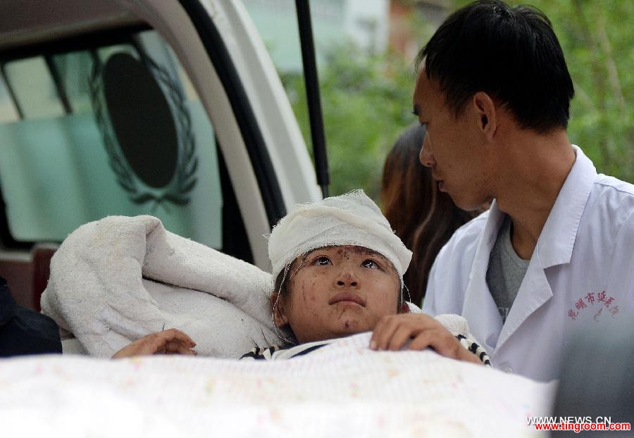 An injured young girl is transferred to an ambulance in quake-hit Longtoushan Township of Ludian County, southwest China