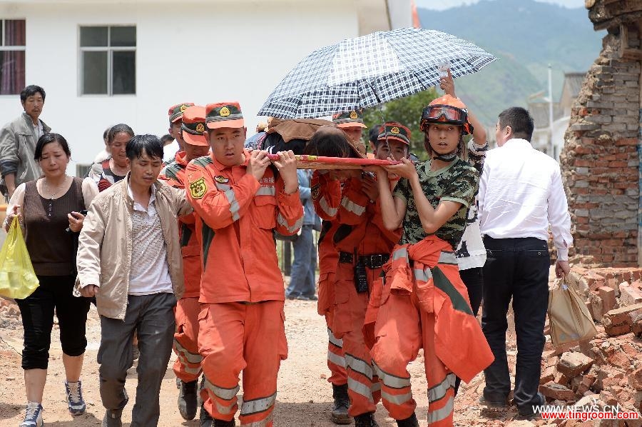 Rescuers transfer an injured person in quake-hit Longtoushan Township of Ludian County, southwest China