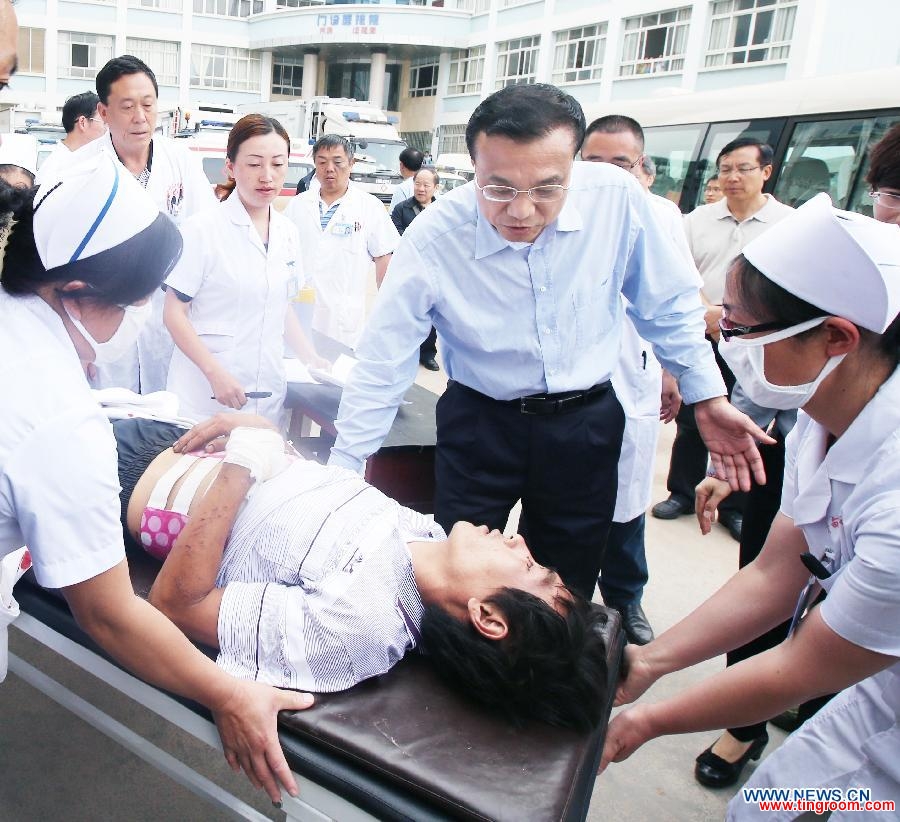 Chinese Premier Li Keqiang (2nd R, front), also a member of the Standing Committee of the Communist Party of China (CPC) Central Committee, offers consolation to a patient who was injured in a 6.5-magnitude earthquake during a visit to the People