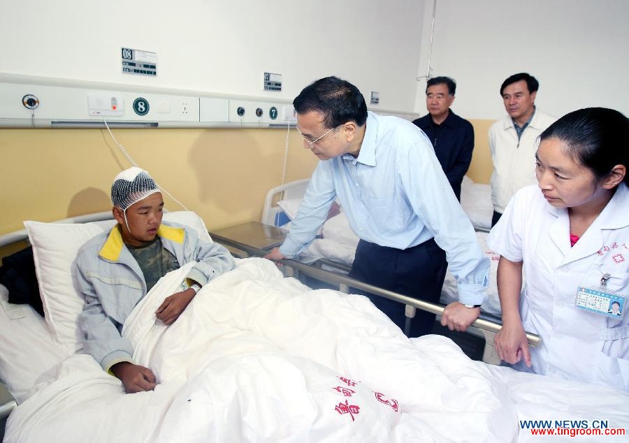 Chinese Premier Li Keqiang (2nd L), also a member of the Standing Committee of the Communist Party of China (CPC) Central Committee, calls upon a patient who was injured in a 6.5-magnitude earthquake during a visit to the People