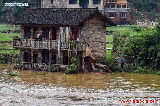 A damaged house is seen stranded in flood in Leishan County, southwest China