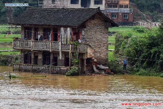 A damaged house is seen stranded in flood in Leishan County, southwest China