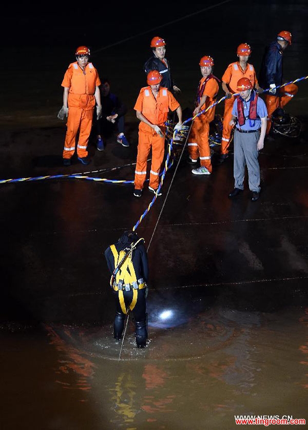 Rescuers work at the site of the overturned passenger ship in the Jianli section of the Yangtze River in central China