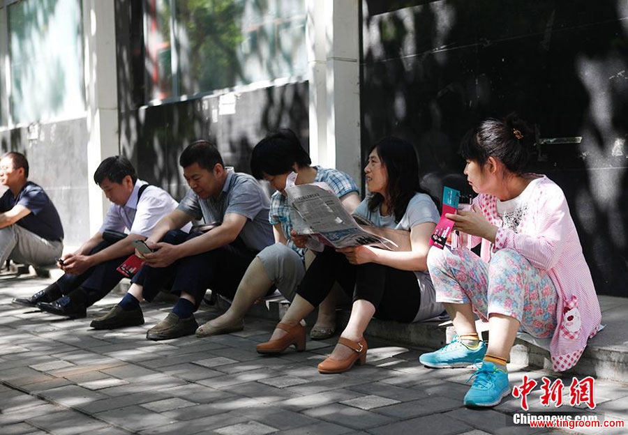 Parents are waiting outside Beijing No.4 High School as their children are taking exams inside in Beijing, capital of China, on June 7, 2015. [Photo: Chinanews.com]