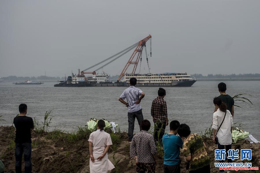 Relatives of the deceased victims of a shipwreck watch the overturned cruise ship 