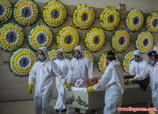 Encoffiners move a body of the victims of the capsized ship accident at the funeral parlour in Jianli, central China
