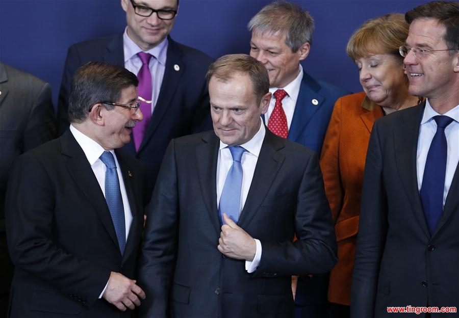 Turkish Prime Minister Ahmet Davutoglu (1st L) talks with German Chancellor Angela Merkel (2nd R) and EU leaders at a group photo session during an extraordinary summit of European Union leaders with Turkey at the European Council headquarters in Brussels, Belgium, March 7, 2016. (Xinhua/Ye Pingfan)