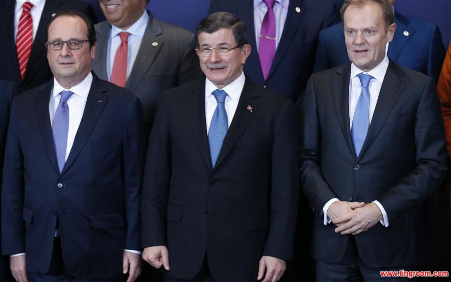 French President Francois Hollande, Turkish Prime Minister Ahmet Davutoglu and European Council President Donald Tusk (from L to R) and EU leaders gather for a group photo during an extraordinary summit of European Union leaders with Turkey at the European Council headquarters in Brussels, Belgium, March 7, 2016. (Xinhua/Ye Pingfan)