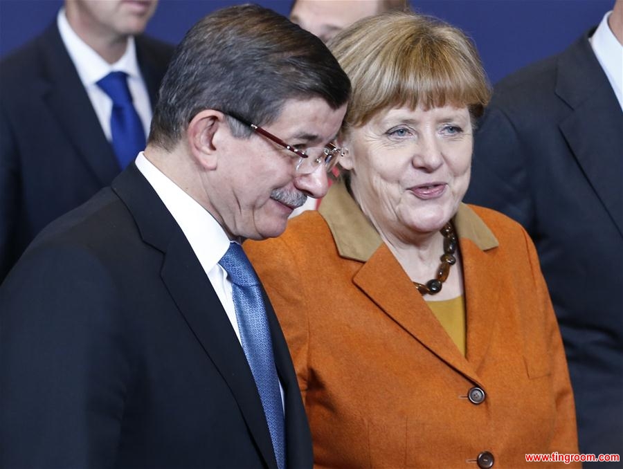 Turkish Prime Minister Ahmet Davutoglu (L) and German Chancellor Angela Merkel speak as they and EU leaders gather for a group photo during an extraordinary summit of European Union leaders with Turkey at the European Council headquarters in Brussels, Belgium, March 7, 2016. (Xinhua/Ye Pingfan)