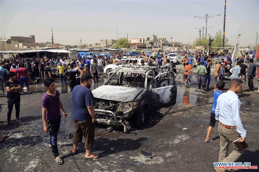 People gather at the explosion site after an attack killing around 16 people and wounding 53 others in Sadr City in eastern Baghdad, Iraq, on May 17, 2016. (Xinhua/Khalil Dawood)