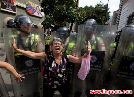 A demonstrator is blocked by Bolivarian National police during an anti-government march to the headquarters of the national electoral body, CNE, in Caracas, Venezuela, Wednesday, May 18, 2016. Opposition protesters were blocked from reaching the CNE as they demand the government allow it to pursue a recall referendum against Venezuela